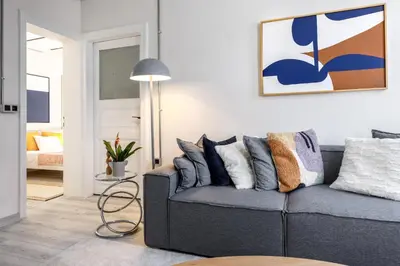 a living room with a gray couch with pillows at Stylish Modern Flat Steps from Istiklal in Istanbul