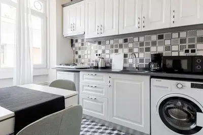 a kitchen with white cabinets and a washer at Stylish Modern Flat Steps from Istiklal in Istanbul
