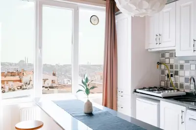 a kitchen with white cabinets and a large window at Stunning City View Luxury Flat by Galata Metro in Istanbul