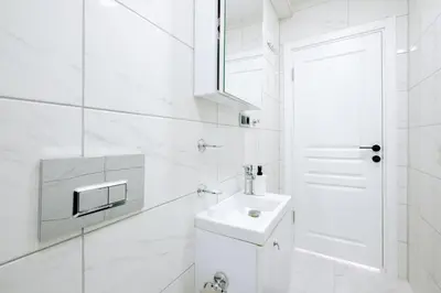 a white bathroom with a sink and a mirror at Stunning City View Luxury Flat by Galata Metro in Istanbul