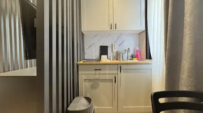 a small kitchen with white cabinets and a sink at Marine Suite in Istanbul