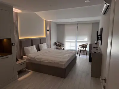 a bedroom with a bed and a desk and a television at Valenzasuites in Tuzla
