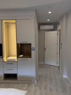 a dressing room with a white cabinet and a door at Valenzasuites in Tuzla