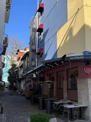 a building with a table and chairs on a street at Valenzasuites in Tuzla