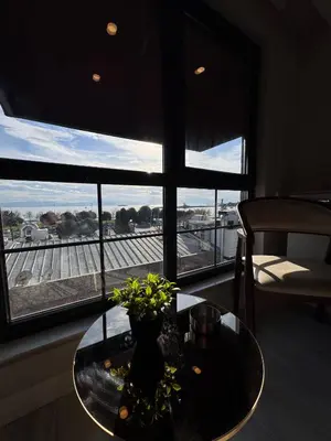 a table with a vase on it in front of a window at Valenzasuites in Tuzla