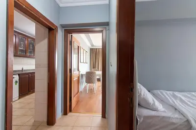 a hallway leading to a bedroom with a bed and a kitchen at Spacious & Modern 3BR Apartment Central Şişli in Istanbul