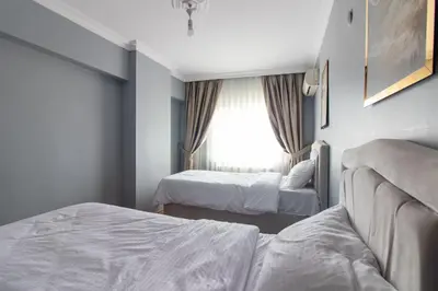 a hotel room with two beds and a window at Spacious & Modern 3BR Apartment Central Şişli in Istanbul