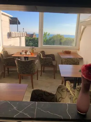 a restaurant with tables and chairs and a large window at BACHOS HOTEL SULTANAHMET sea view terrace in Istanbul
