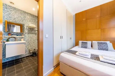 a bedroom with a bed and a bathroom with a sink at King Suite Hotel Beşiktaş in Istanbul
