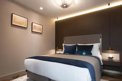 a bedroom with a large bed with blue pillows at Noble22 Suites-Special Category in Istanbul