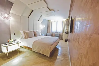 a bedroom with a large bed and a table at Maroon Hotel Pera in Istanbul