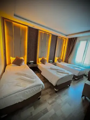a hotel room with three beds in it at Liman Hotel in Istanbul