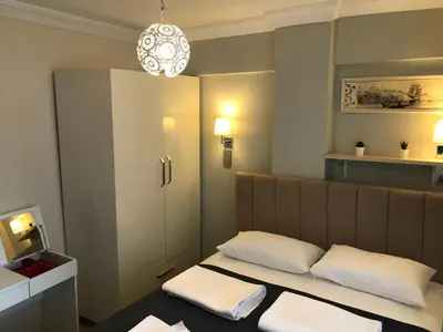 a small room with a bed with two white pillows at Goji's Apartments in Istanbul