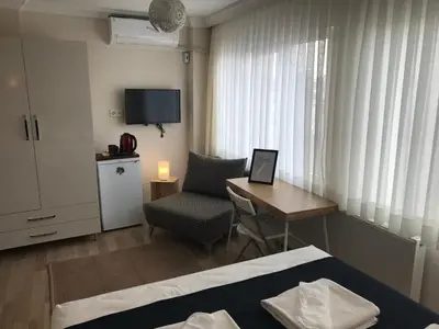 a hotel room with a desk and a bed and a chair at Goji's Apartments in Istanbul