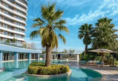 a swimming pool with a palm tree in front of a building at Radisson Blu Hotel Istanbul Ottomare in Istanbul
