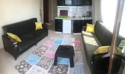 a living room with two green couches and a table at Lapina Suite & Restaurant in Cebeci