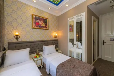 a hotel room with two beds and a mirror at Alpek Hotel in Istanbul