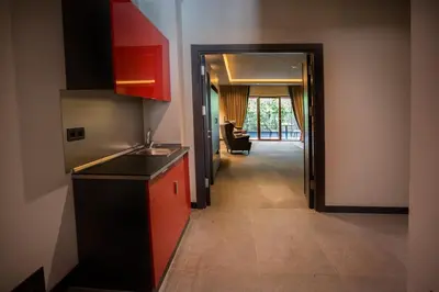 a kitchen with red cabinets and a hallway leading to a living room at Cityloft 24 in Istanbul