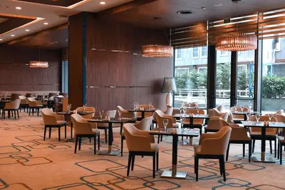 a dining room with tables and chairs and windows at Mercure Istanbul West Hotel & Convention Center in Istanbul
