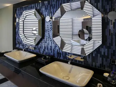 a bathroom with two sinks and two mirrors at Pullman Istanbul Hotel & Convention Center in Istanbul