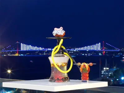a cupcake on a tray on a table with a view of a bridge at Glamour Hotel Istanbul Sirkeci in Istanbul