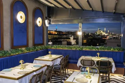 a restaurant with tables and chairs and a view of the city at Glamour Hotel Istanbul Sirkeci in Istanbul