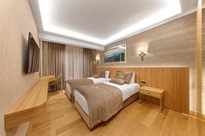 a hotel room with two beds and a desk at Lady Diana Hotel in Istanbul