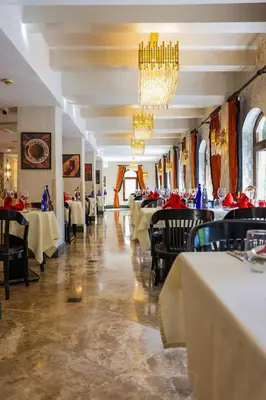 a dining room with tables and chairs and chandeliers at Crowne Plaza Istanbul - Old City by IHG in Istanbul
