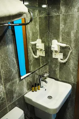 a bathroom with a sink and a mirror and a toilet at Reyyan Hotel in Istanbul