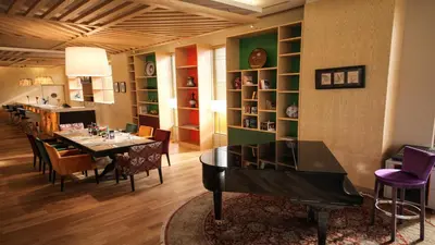 a dining room with a table and a piano at ADM Grand Hotel in Istanbul