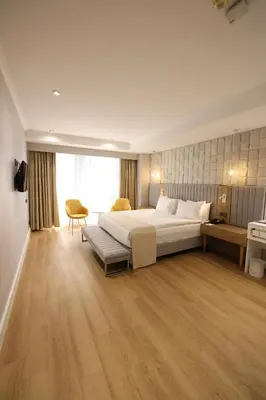 a large bedroom with a large bed and a chair at ADM Grand Hotel in Istanbul