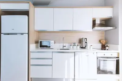 a kitchen with white cabinets and a microwave at Serenity Suites Istanbul Airport in Istanbul