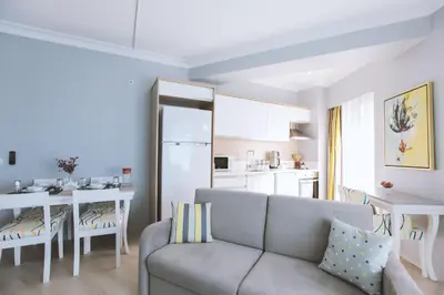 a living room with a couch and a kitchen at Serenity Suites Istanbul Airport in Istanbul