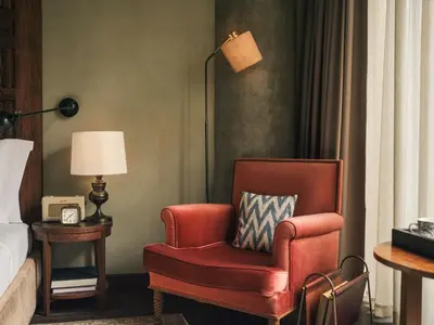 a red chair and a lamp in a hotel room at Soho House Istanbul in Istanbul