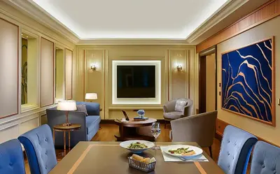a living room with a table and chairs and a television at The Ritz-Carlton, Istanbul at the Bosphorus in Istanbul