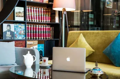 an apple laptop on a table in front of a couch at Arise Hotel Golden Horn in Istanbul