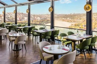 a restaurant with tables and chairs and a view of a river at Arise Hotel Golden Horn in Istanbul