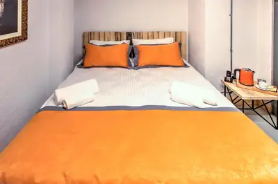 a bed with orange and white sheets and pillows at Vavien Hotel in Istanbul