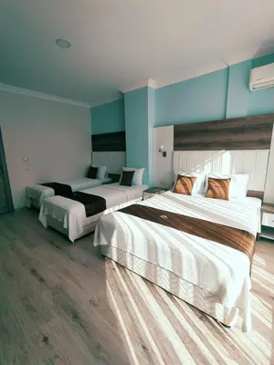two beds in a room with blue walls at Ceti̇n Presti̇ge Resort in Erdek