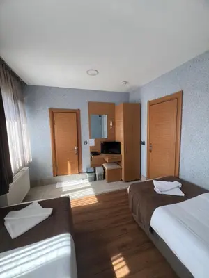 a hotel room with two beds and a living room at Okur Otel in Istanbul
