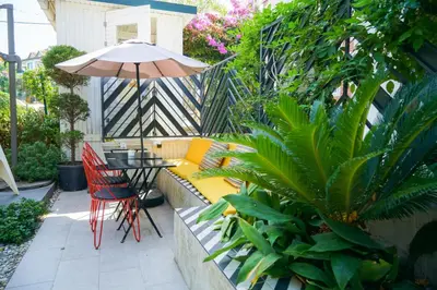 a patio with a couch and a table and an umbrella at Serguzest Otel in Buyukada