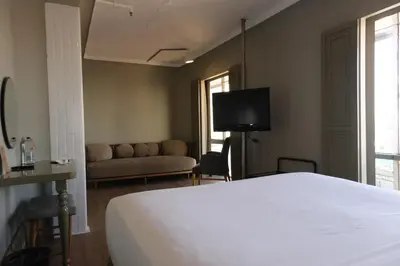 a bedroom with a bed and a couch and a tv at The Cettia Istanbul in Istanbul