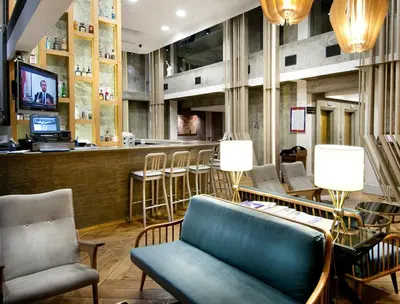 a lobby with a bar with a couch and chairs at The Cettia Istanbul in Istanbul