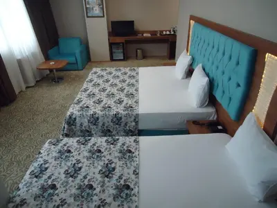 a hotel room with two beds and a chair at Golden Lounge Hotel in Istanbul