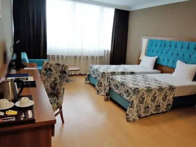 a hotel room with two beds and a table at Golden Lounge Hotel in Istanbul
