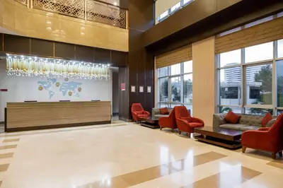 a lobby with red chairs and a waiting room at Clarion Hotel Istanbul Mahmutbey in Istanbul