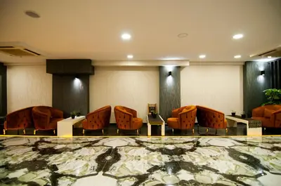 a waiting room with orange chairs and tables at Vali Konak Hotel Nişantaşı in Istanbul