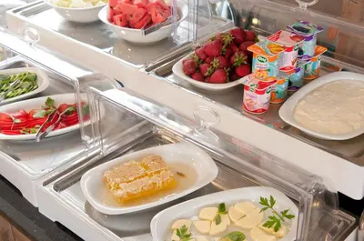 a refrigerator filled with plates of food and fruit at Vali Konak Hotel Nişantaşı in Istanbul