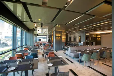 a dining room with tables and chairs and windows at Wish More Hotel Istanbul in Istanbul