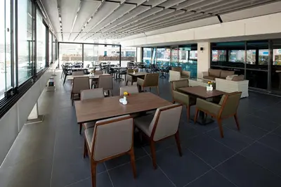 a restaurant with tables and chairs and windows at Nearport Hotel Sabiha Gokcen Airport in Istanbul